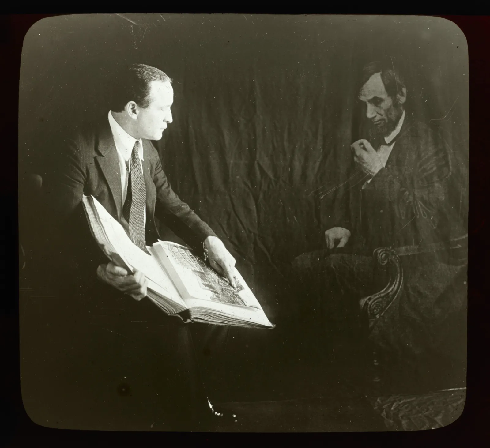 Houdini seated at left with an open book; a translucent Abraham Lincoln sits in an armchair at right